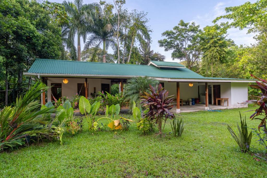 a small house with a green roof at Osos Caribeños - with Garden - 400m from the Beach in Punta Uva