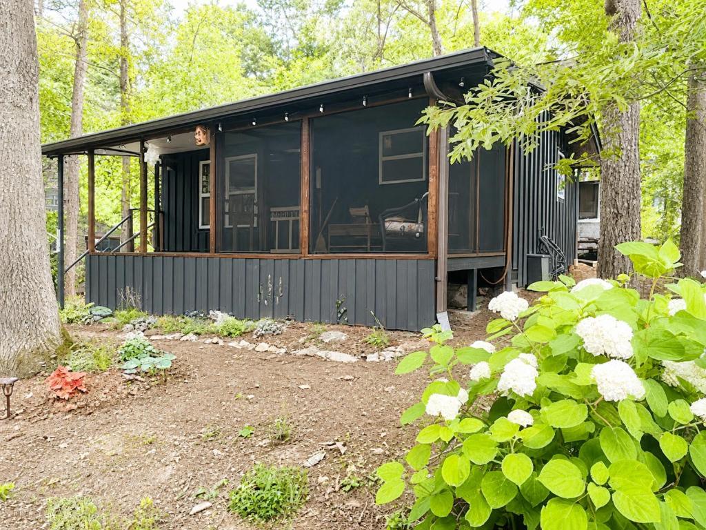a black cabin in the middle of the woods at Cameron's Cottage at The Lake in Tallassee