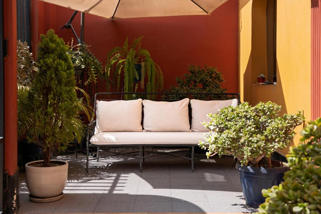 a white couch sitting on a patio with plants at Kontiki Miraflores in Lima