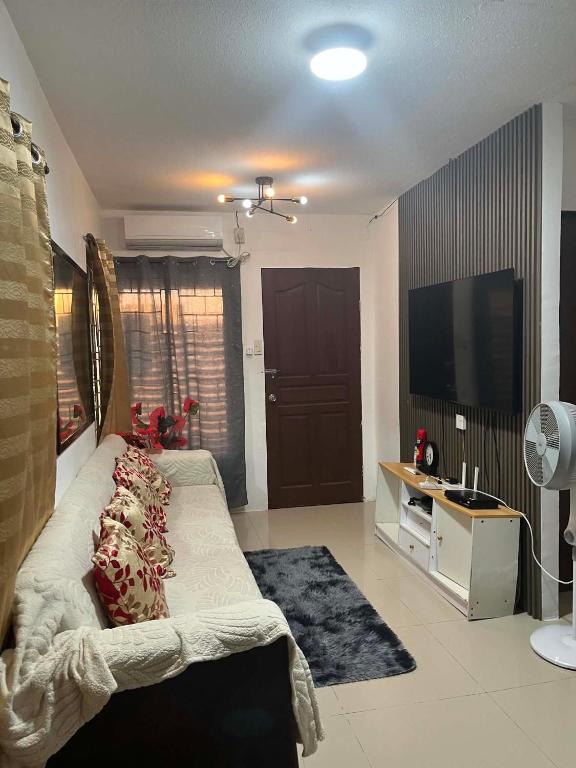 a living room with a couch and a flat screen tv at Vin's Transient WiFi Netflix City Hall-DRMC-EPark in Tagum