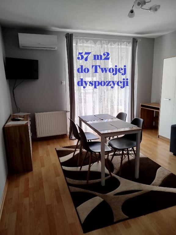 a dining room with a table and chairs in front of a window at Apartament Dunikowskiego 57m2 in Lublin