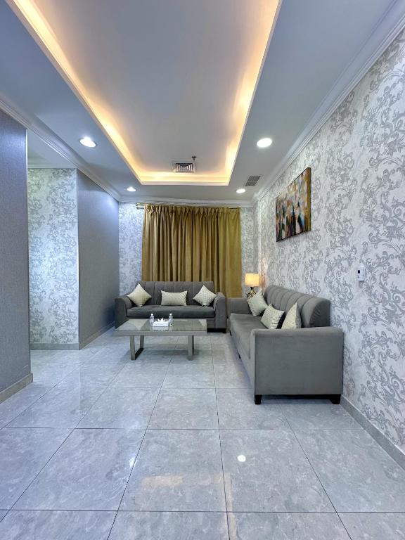 a living room with two couches and a table at كريستال الخليج للشقق الفندقيه in Kuwait