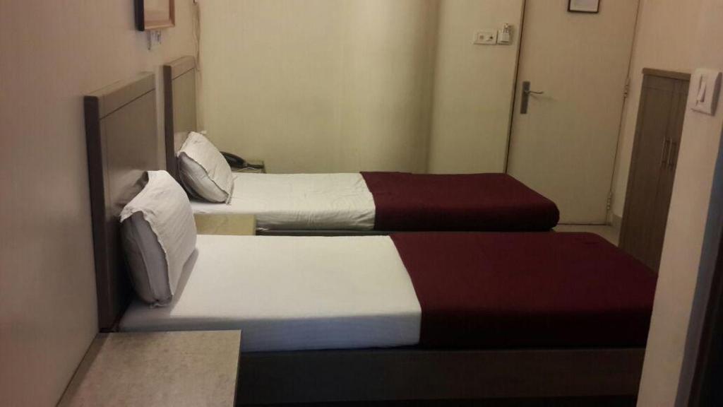 two beds in a small room with two beds sidx sidx sidx at Hotel Zenith in Surat