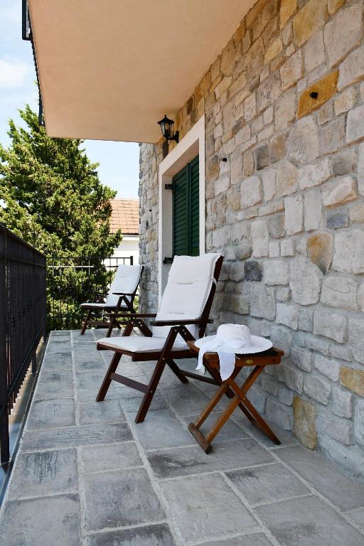 a patio with two chairs and a stone wall at VILLA MATIJA in Cesarica