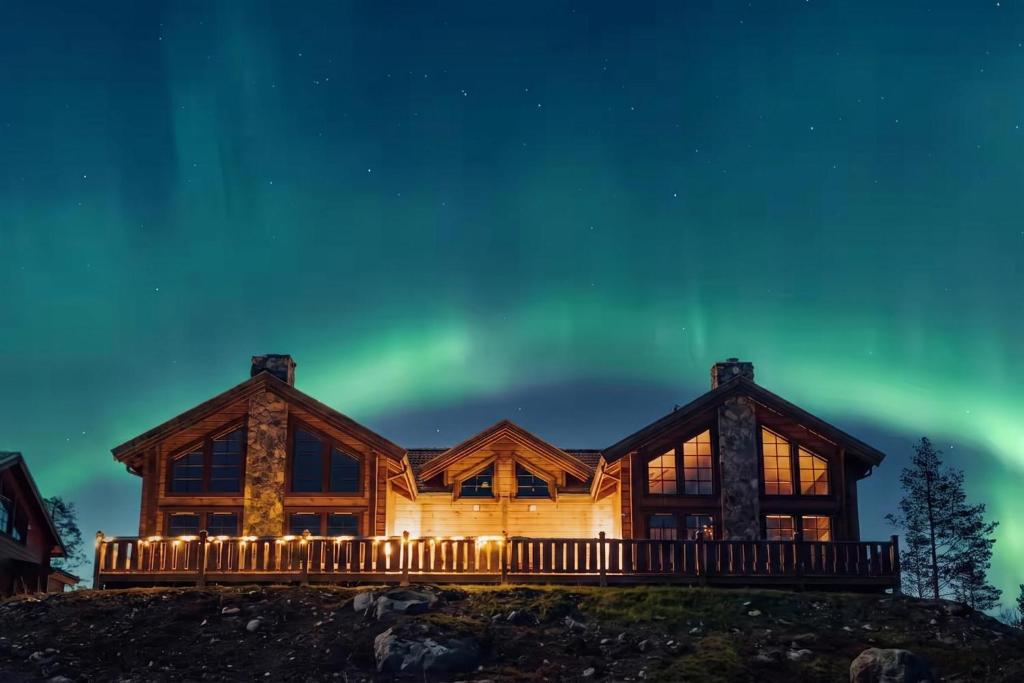 a log cabin at night with the aurora at Idre Luxury Chalet Winter Haven /w Sauna - Happy Rentals in Idre