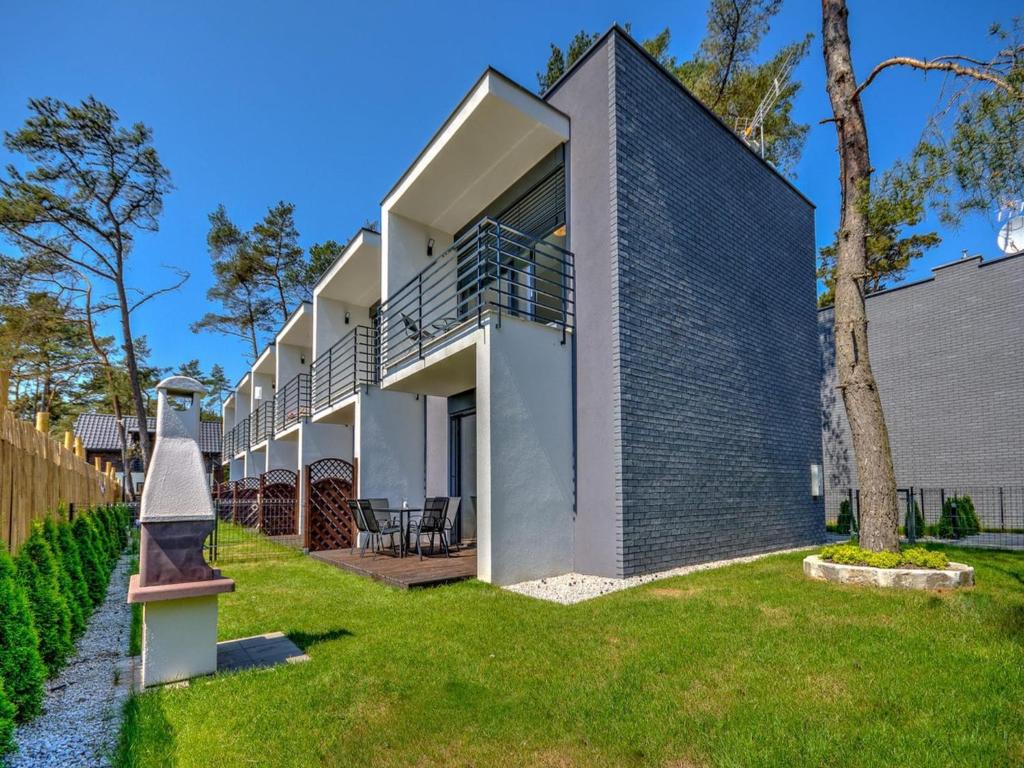 a modern house with a gray brick wall at Comfortable holiday home with a garden and a pool in Pobierowo