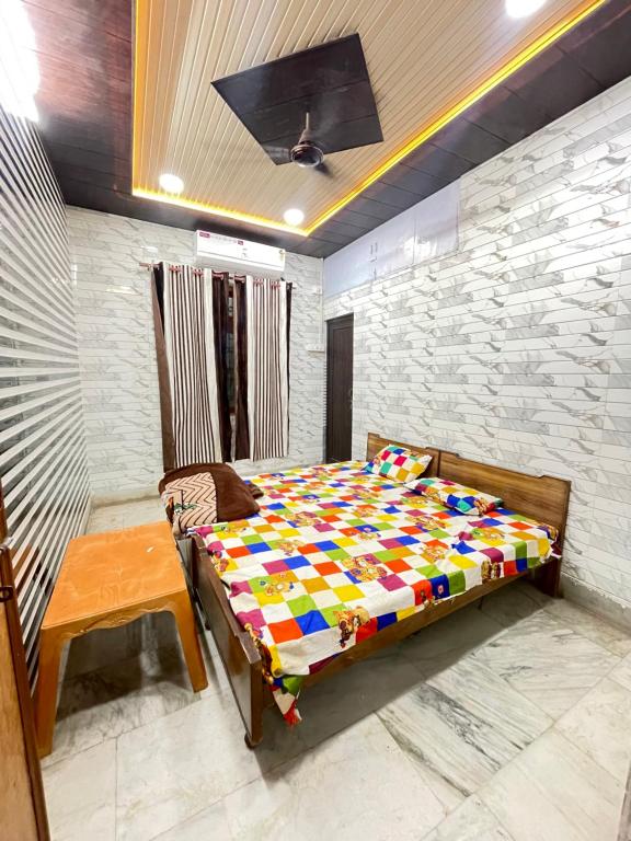 a bedroom with a bed and a table in it at Dwarkapuri Paras guest house in Mathura
