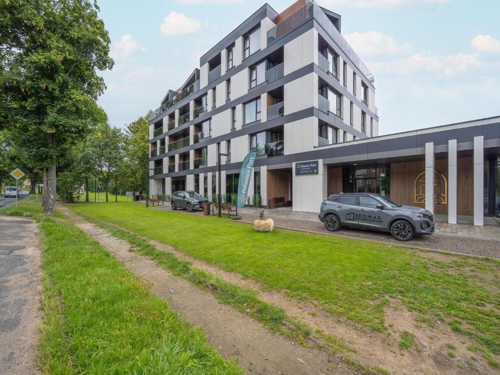 a building with cars parked in front of it at Holiday studio with balcony, indoor pool, sauna in Polanica-Zdrój