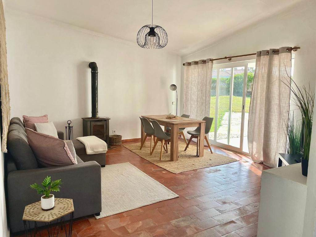 a living room with a couch and a dining room table at Casa da praia in Aljezur