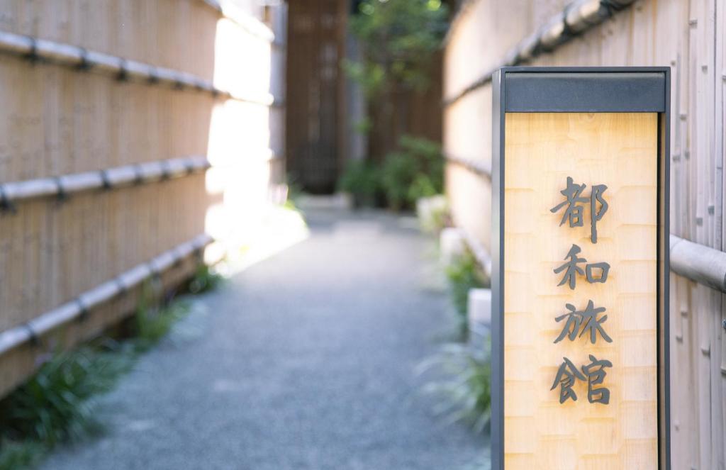 a sign with chinese writing on the side of a building at Towa Ryokan in Kyoto