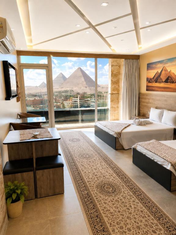 a hotel room with two beds and a large window at pyramids view suite/vista piramidi in Cairo