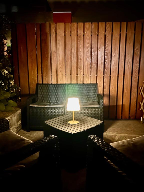 a table with a lamp in a room with a couch at Bernina House in Chiesa in Valmalenco