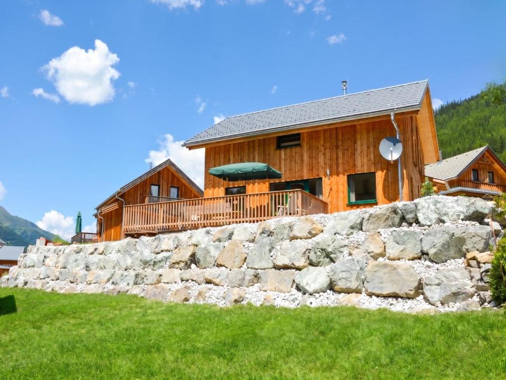a log house with a stone wall in front of it at Das Edelweiss in Hohentauern