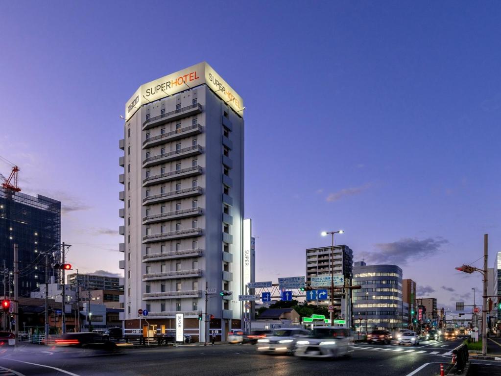 a tall building on a city street with cars at Super Hotel Yokkaichi Route 1 in Yokkaichi