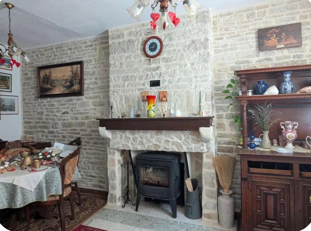 a living room with a stone fireplace and a table at L Ecrin de Mussy in Mussy-sur-Seine