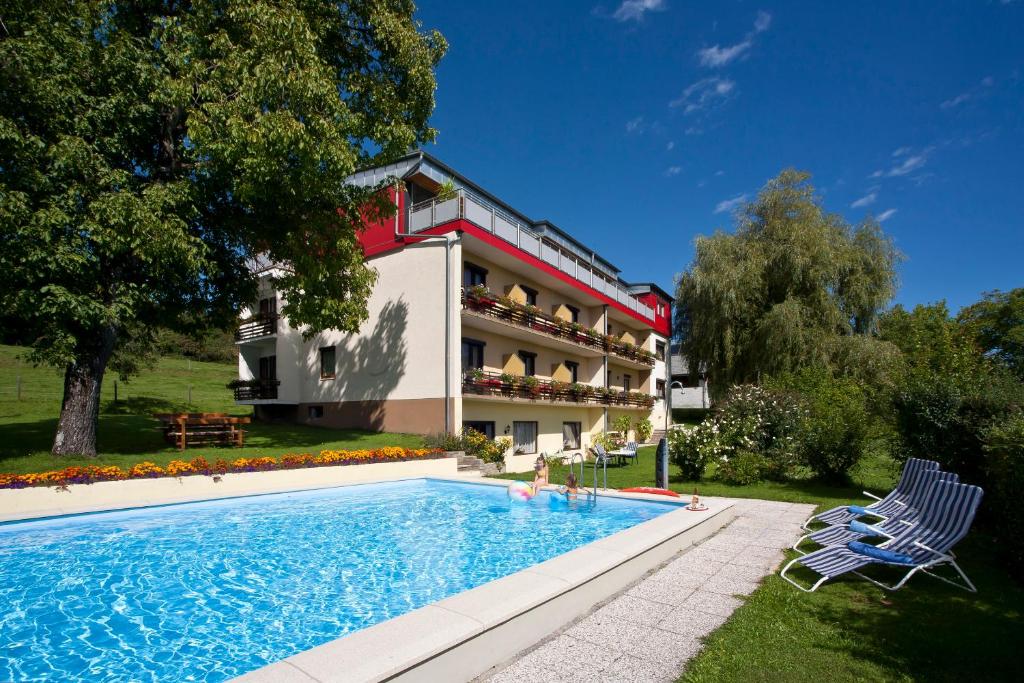 une maison avec une piscine à côté d'un bâtiment dans l'établissement Haus Kaiser, à Schiefling am See