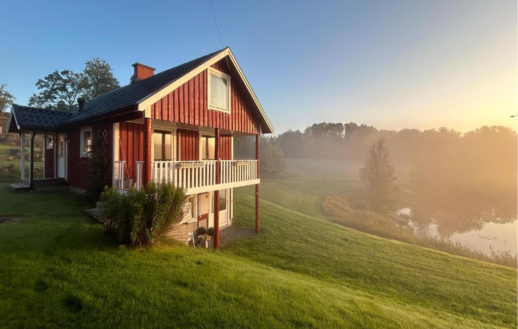 a house on a hill with fog in the background at Lovely Home In Örkelljunga With Sauna in Orkelljunga