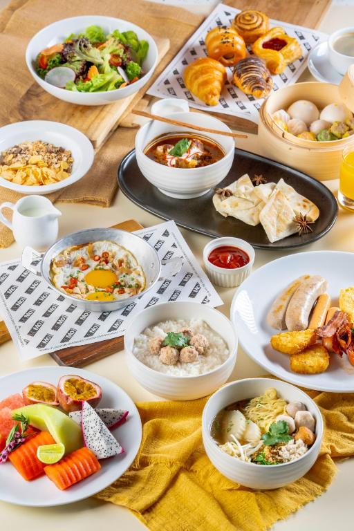 A generous breakfast-style spread with eggs, pastries, fruit, noodles and dumplings.