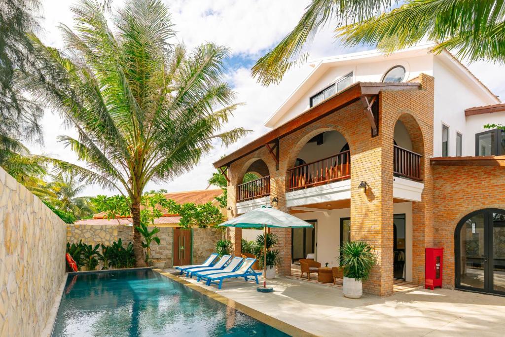 a villa with a swimming pool and a house at Salt Villa 5BR Beachfront by HUA in An Bàn (2)