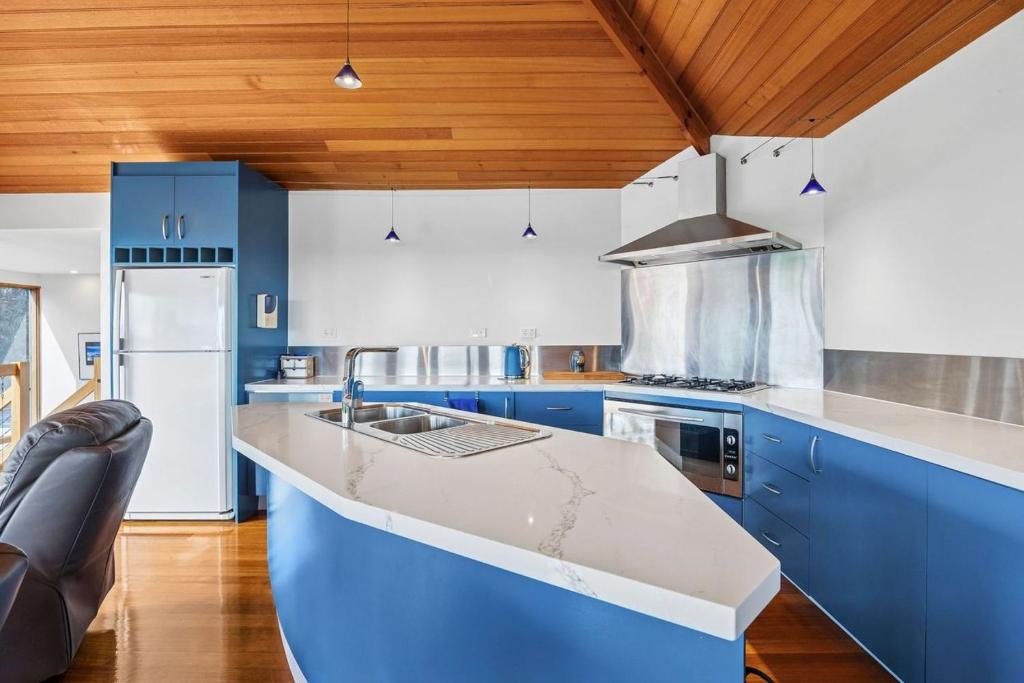 a kitchen with blue cabinets and a counter top at Blue Water - BYO Linen in Anglesea
