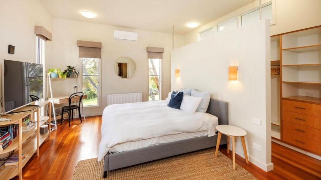a bedroom with a bed and a desk and a television at Kyarra in Aireys Inlet