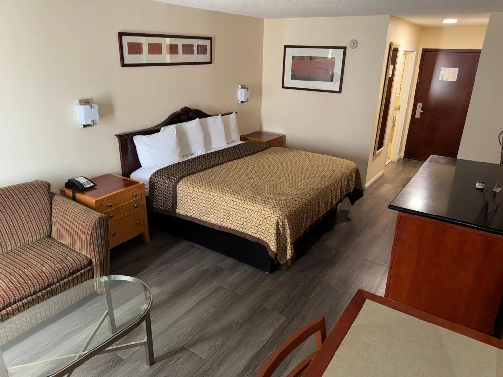 a hotel room with a bed and a chair at Scotland Neck Inn in Scotland Neck