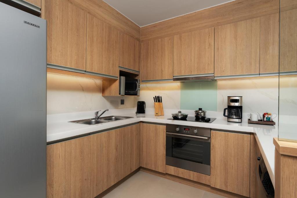 A compact modern apartment kitchen with full-size appliances and generous cabinetry.