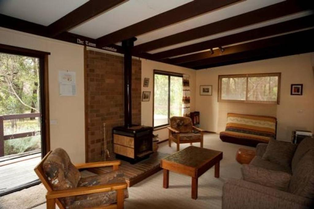 a living room with a fireplace and a bed at 40 Aireys Street in Aireys Inlet