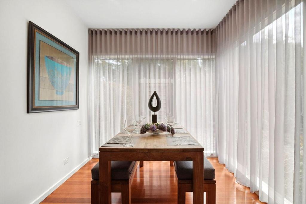a table in a room with white curtains at Aireys Oasis in Aireys Inlet