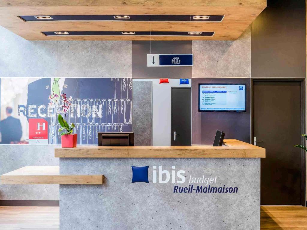 an office lobby with a reception counter with a rodsirschirschlation sign at ibis budget Rueil Malmaison in Rueil-Malmaison