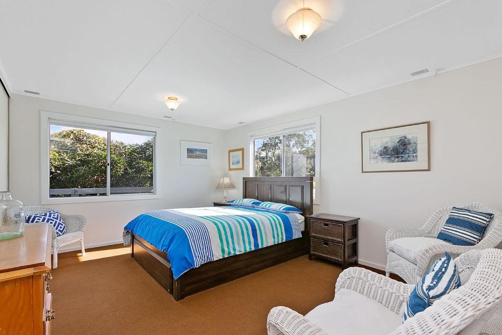 a bedroom with a bed and two chairs at Mirimar in Apollo Bay