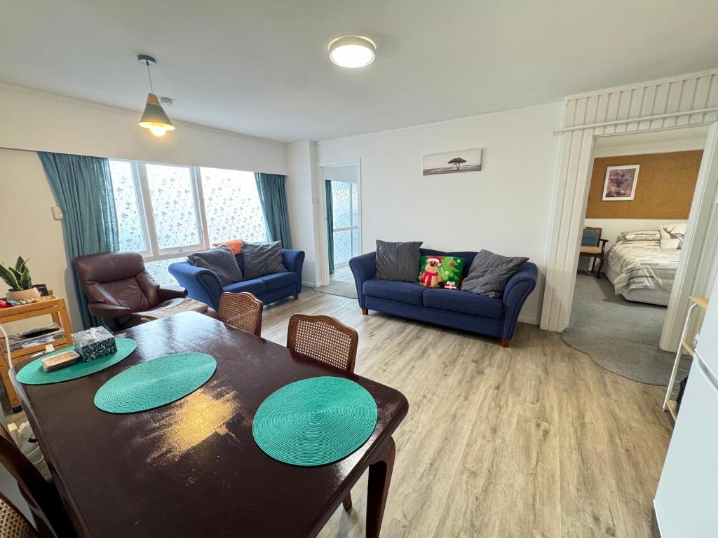 a living room with a dining table and a living room at Delight at Golf in Auckland