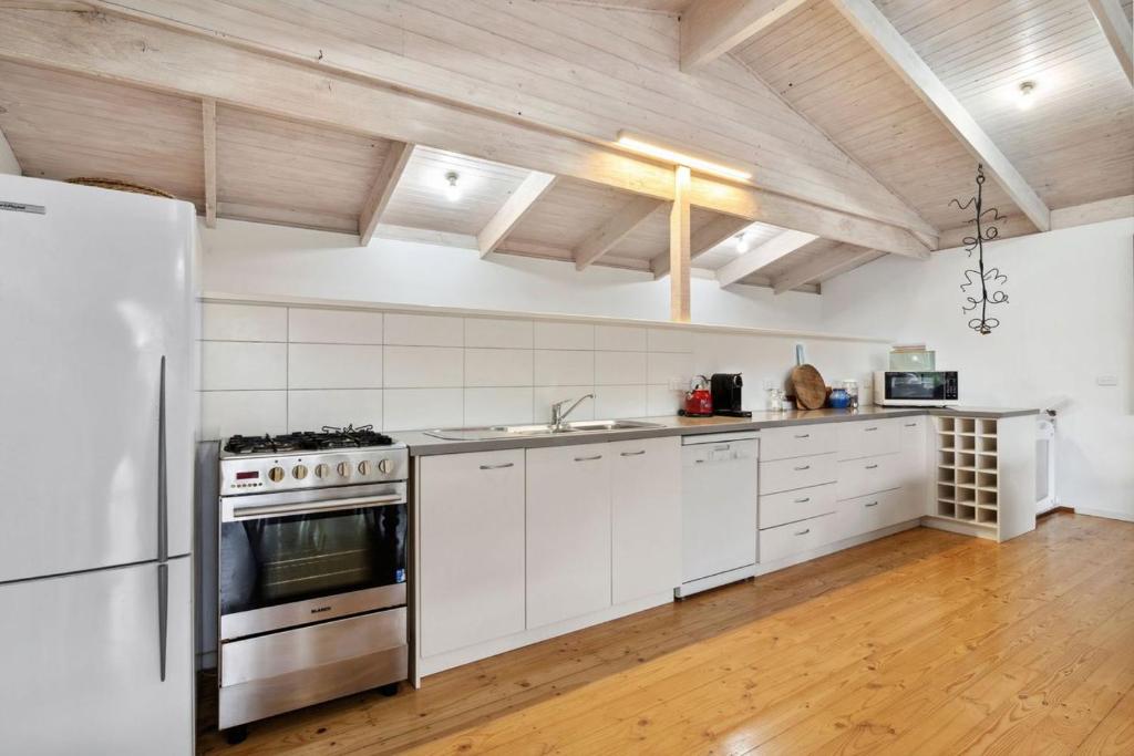 a kitchen with white appliances and a wooden ceiling at Coastwalk in Aireys Inlet