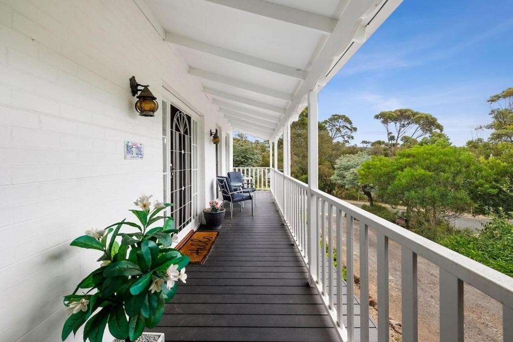 a porch of a white house with chairs and plants at Noble Villa - BYO Linen in Anglesea