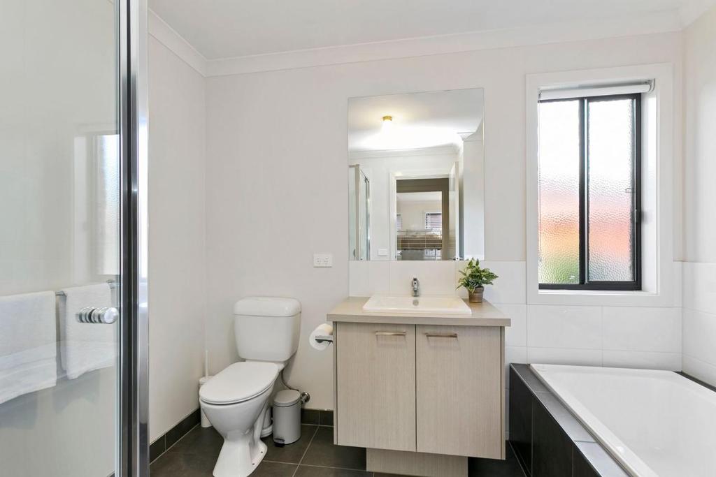a bathroom with a toilet and a sink and a tub at Merihaven in Apollo Bay