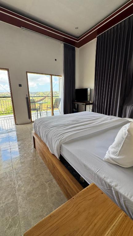 a bedroom with a large bed and a balcony at Payas Private Farm Villa in Praya