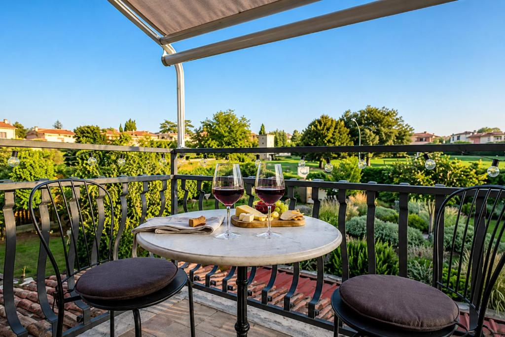 a table with two glasses of wine on a balcony at Appartamento la casa di Mary Anguillara Sabazia-Lago,Relax e Roma a portata di treno in Anguillara Sabazia
