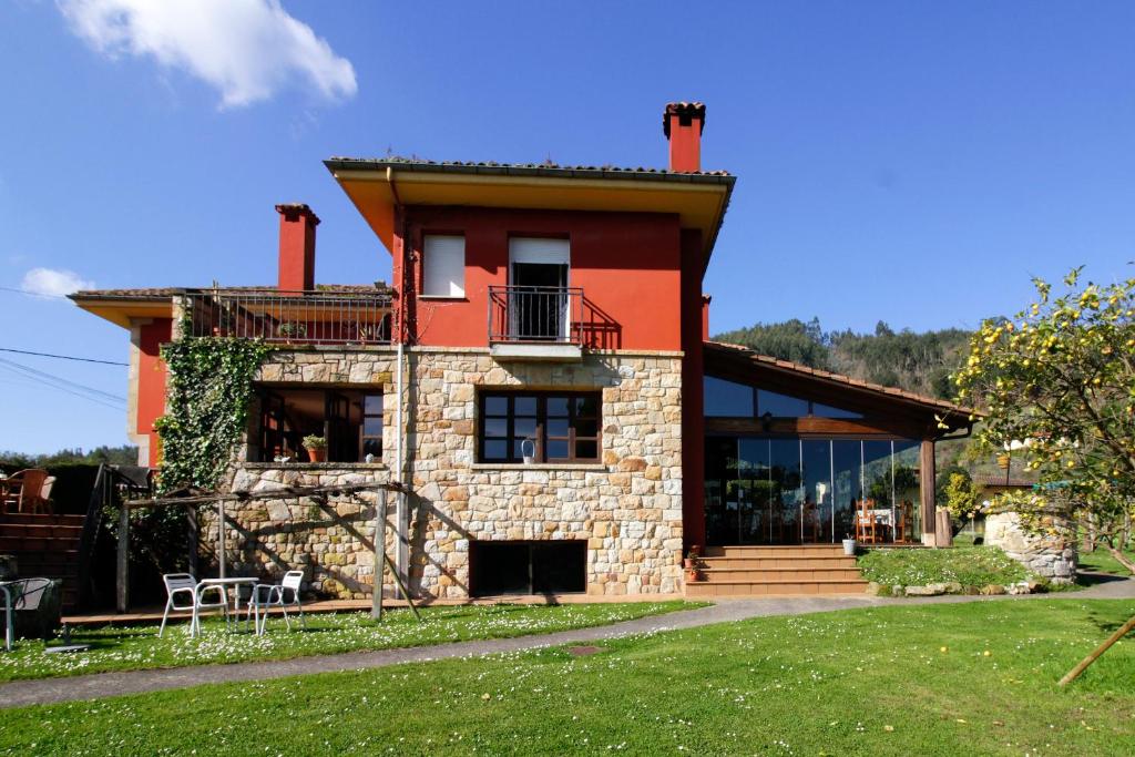 a house with a red roof and a yard at Hotel Rural Alavera in San Martin del Mar