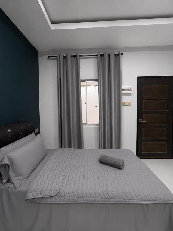 a bedroom with a large bed with a towel on it at Chenang Private Pool Villa & Cottage in Pantai Cenang