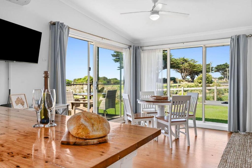 a living room with a table and a dining room with a view at Beachfront Apartment at Apollo in Apollo Bay