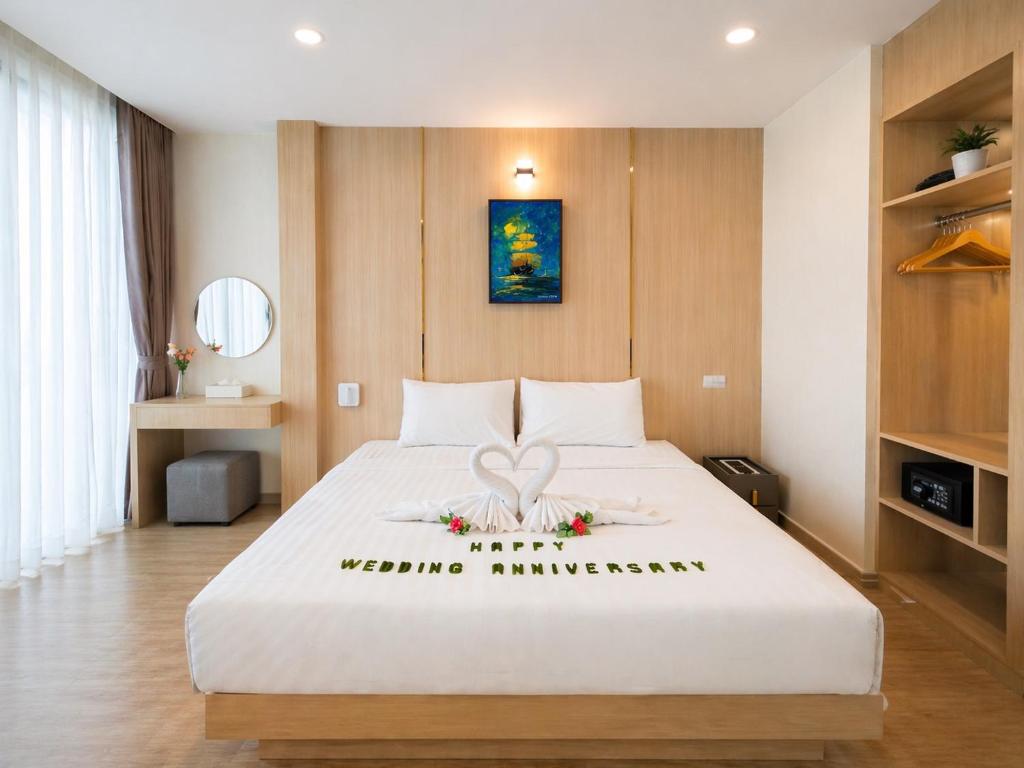 a bedroom with a large white bed with flowers on it at โรงแรมดีวิว โกลเด้นไทรแองเกิ้ล เชียงแสน - Dview Golden Triangle Hotel Chiangsaen in Golden Triangle