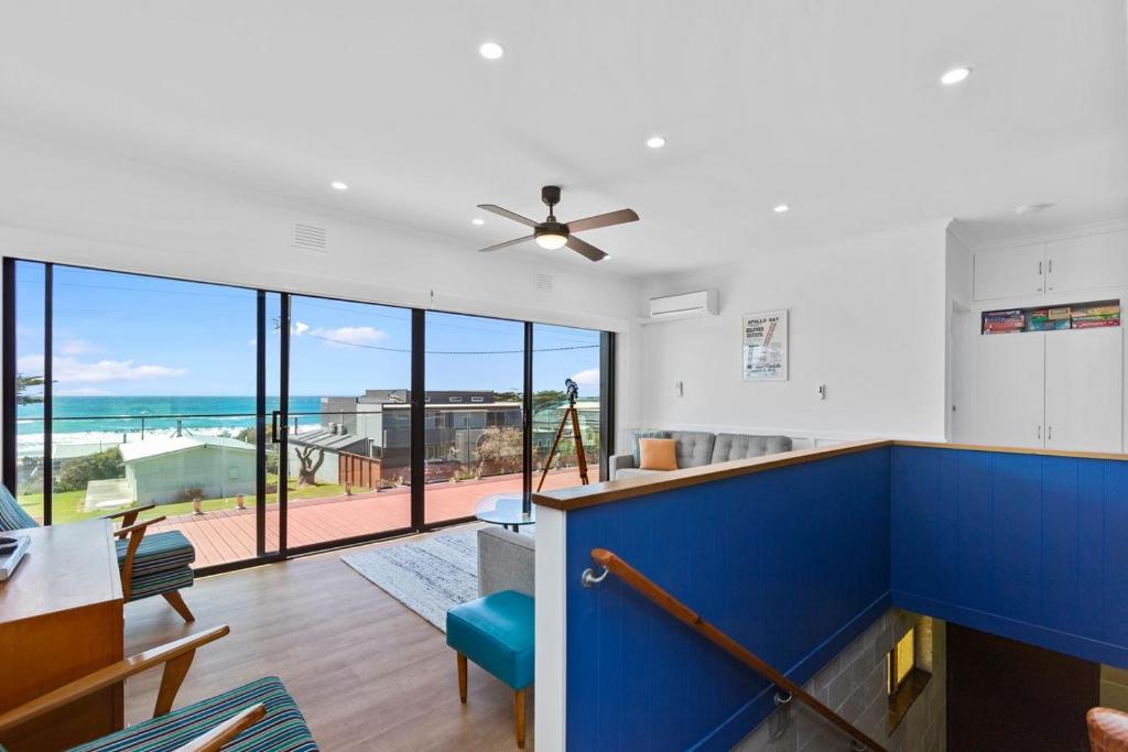 a living room with a blue wall and a ceiling fan at Casino Views in Apollo Bay