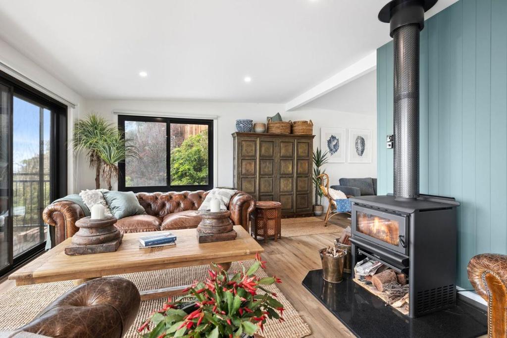 a living room with a couch and a fireplace at Omaroo in Wye River