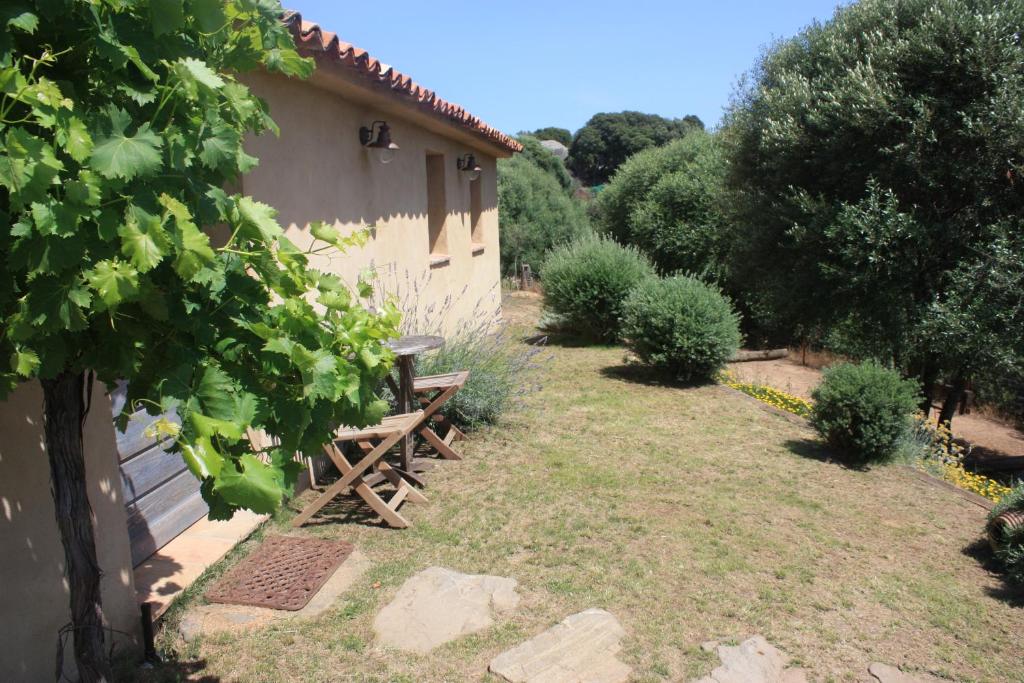 um jardim com um banco de madeira ao lado de um edifício em Auberge U Sirenu em Sartène
