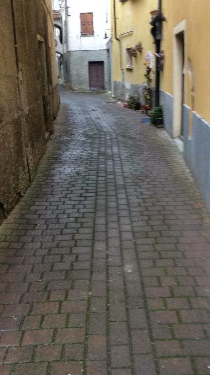 an empty alley with a brick road between two buildings at B B Griffondoro in Cantalupo Ligure