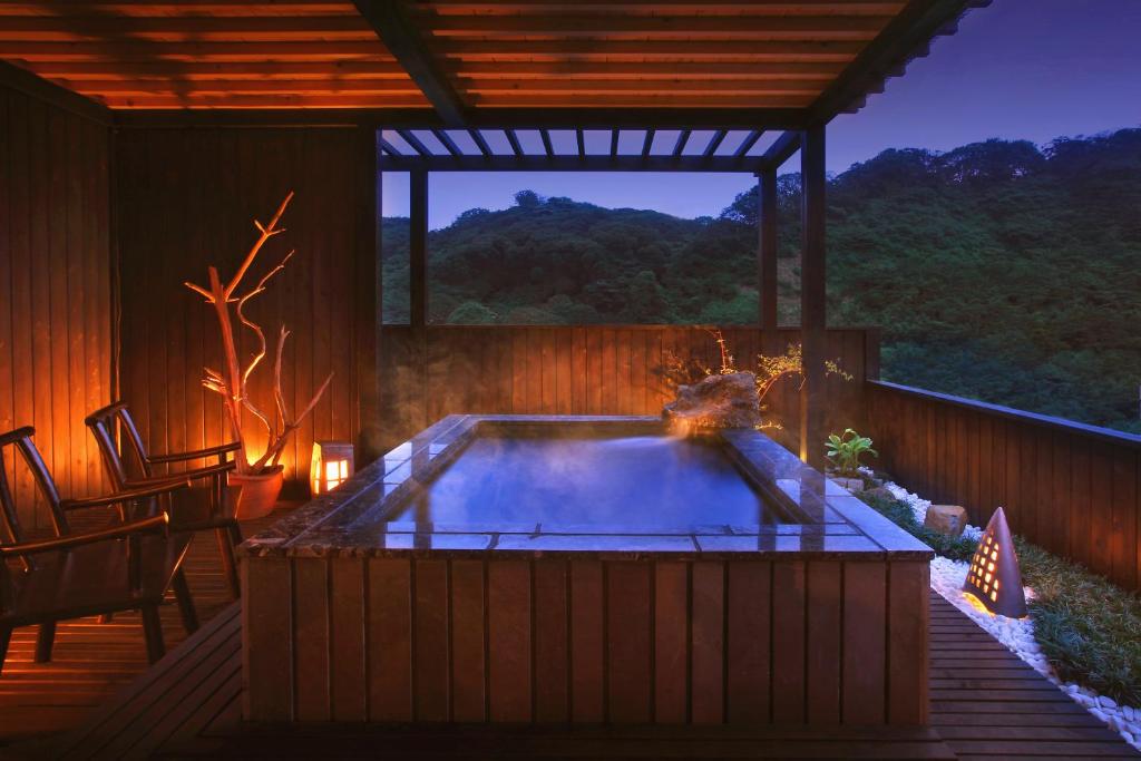 a hot tub in a patio with a table and chairs at 旅館かわな -Ryokan Kawana- in Kimitsu