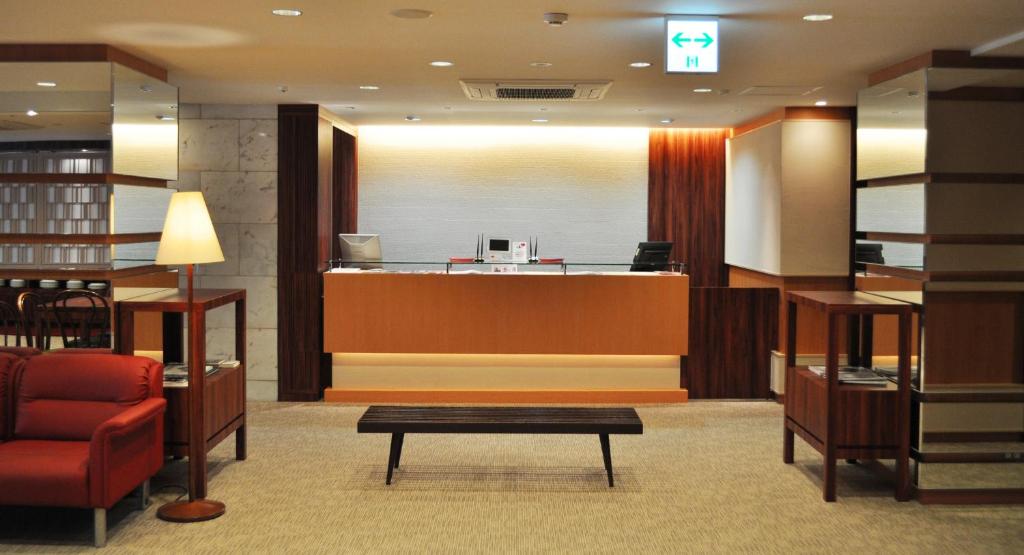 a lobby with a waiting area with a waiting table at Hotel Sunroute Kumamoto in Kumamoto