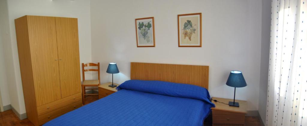 a bedroom with a blue bed and a wooden cabinet at Tagus Host - 40308AL- 44211AL in Santarém