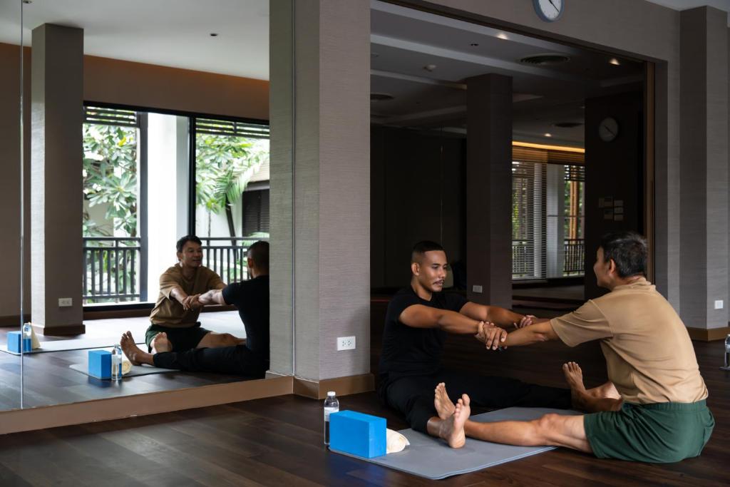 A yoga and stretching session taking place in a mirrored studio.