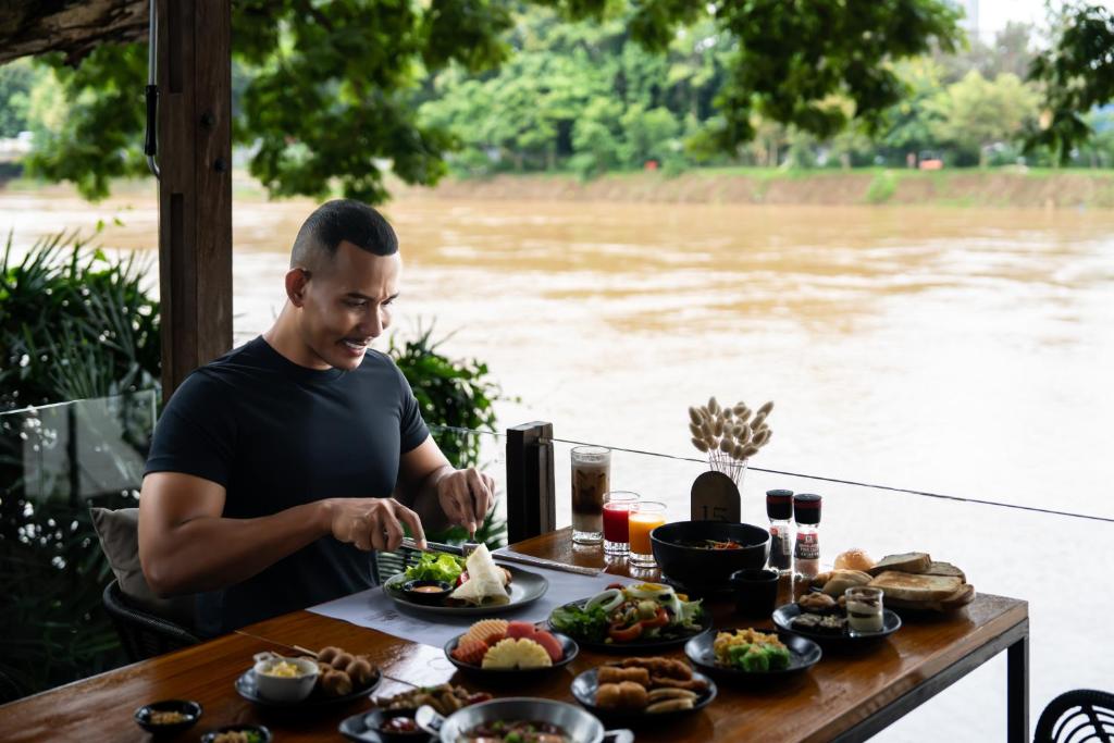An outdoor riverside breakfast with a broad spread of dishes and drinks.